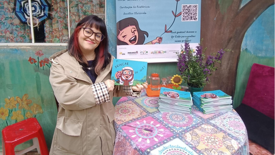 Larissa Hofbauer apresenta a obra "Brincar de Quê?", que integra projeto de incentivo à leitura e ao brincar. Foto: Divulgação